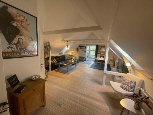 a living room with a couch and a table at Naturskøn landidyl på Ibækgaarden - I egen bolig in Vejle