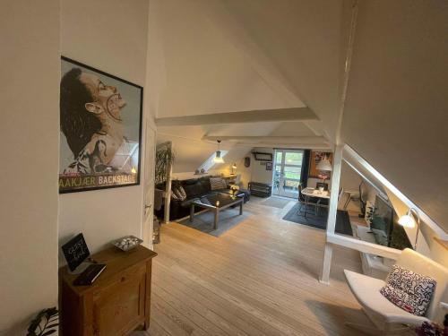 a living room with a staircase leading to a living room at Naturskøn landidyl på Ibækgaarden - I egen bolig in Vejle