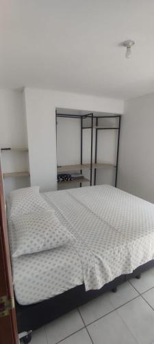 a bedroom with a bed in a white room at 2 Bedroom 1 Bathroom Cabecera with Doorman in Bucaramanga