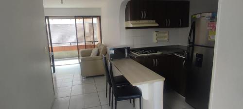 a small kitchen with a counter and a refrigerator at 2 Bedroom 1 Bathroom Cabecera with Doorman in Bucaramanga
