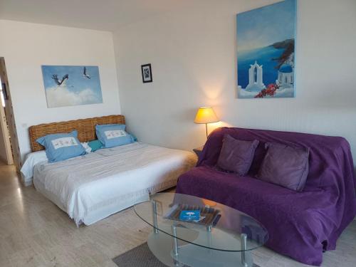 - une chambre avec un lit, un canapé et une table en verre dans l'établissement Grand studio vue mer à Marina Baie des Anges, à Villeneuve-Loubet