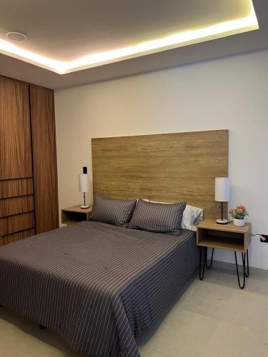 a bedroom with a large bed with two lamps on tables at Departamento al Norte de Aguascalientes in Aguascalientes