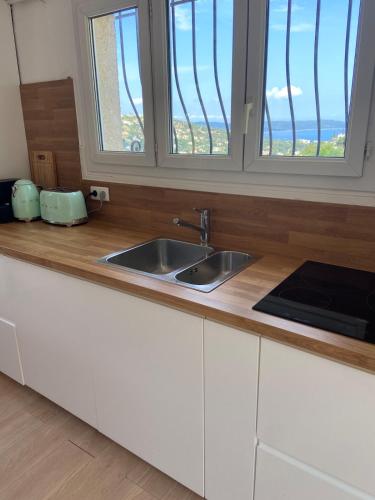 - un comptoir de cuisine avec évier et 2 fenêtres dans l'établissement Holidayhome with a view - Les Lucines, à Cavalaire-sur-Mer