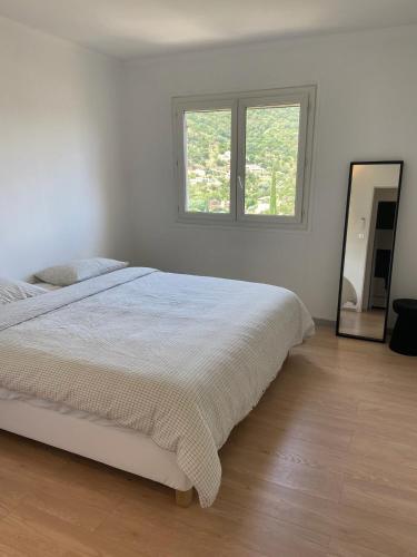 une chambre blanche avec un lit et un miroir dans l'établissement Holidayhome with a view - Les Lucines, à Cavalaire-sur-Mer