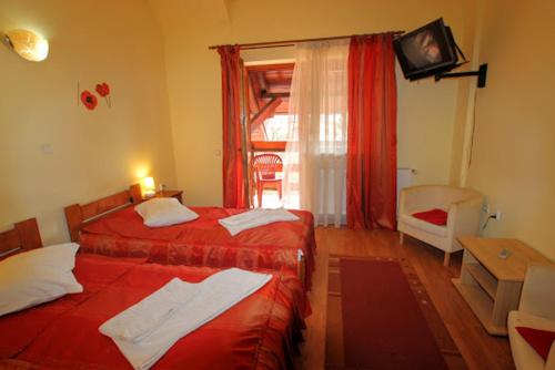 a hotel room with two beds and a window at Pension Bittner in Braşov