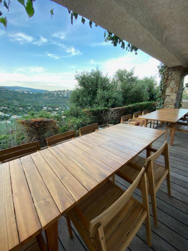 une table en bois et des bancs sur une terrasse dans l'établissement Holidayhome with a view - Les Lucines, à Cavalaire-sur-Mer