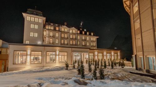 a large building in the snow at night at Hotel Mürren Palace in Mürren