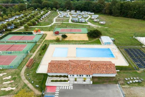 - une vue sur le court de tennis et la piscine dans l'établissement Camping Paradis Les Rives de l'Adour, à Saint-Sever