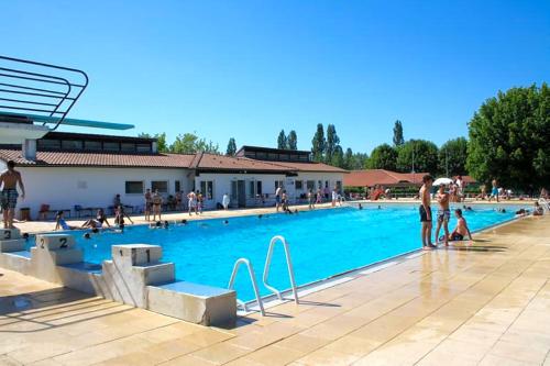 un groupe de personnes debout autour d'une piscine dans l'établissement Camping Paradis Les Rives de l'Adour, à Saint-Sever