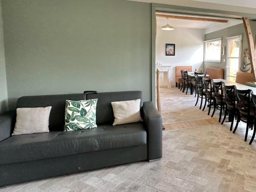 a living room with a couch and a table and chairs at Maison - 2 chambres - Terrasse - Babyfoot in Verton
