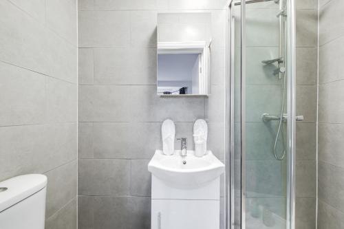a white bathroom with a sink and a shower at Central 1bed flat - 10 Min to Northern Line - Workspace - Parking - New Memory Foam Sofabed in Colindale