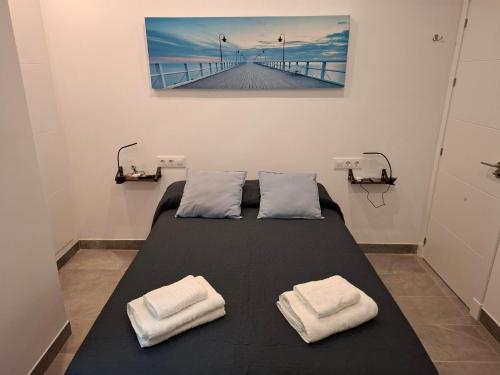 a bed in a room with two white towels on it at VILLA caracolillo MAR in Chiclana de la Frontera