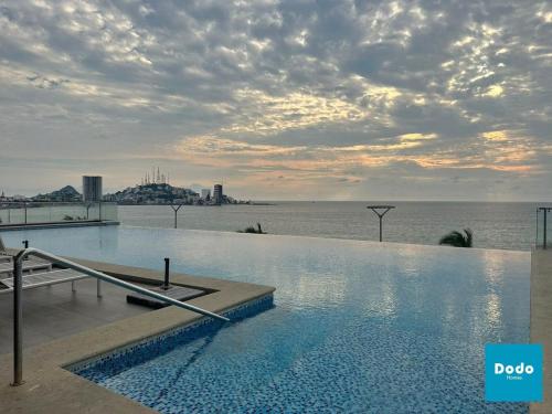 a swimming pool on top of a building next to the water at Departamentos en Sunset View frente al malecón de Mazatlán in Mazatlán