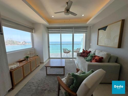 a living room with a couch and a view of the ocean at Departamentos en Sunset View frente al malecón de Mazatlán in Mazatlán