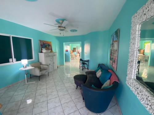 a living room with blue walls and a couch at Casa Azul - Apartment in San Felipe de Puerto Plata