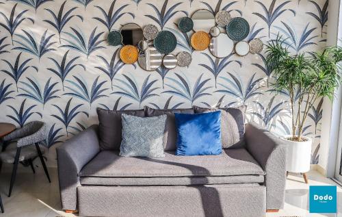 a living room with a couch and a wall with a wallpaper at Departamentos en Sunset View frente al malecón de Mazatlán in Mazatlán