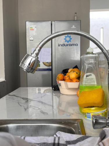 a kitchen sink with a faucet and a bowl of oranges at Casa playa in Colán