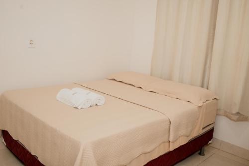 a bed with a white towel on top of it at Pousada Muiraquitã Parintins in Parintins