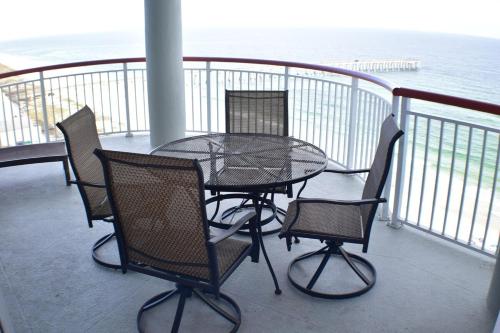 a table and chairs on a balcony with the ocean at Beach Front Next To Pier in Navarre