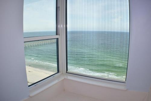 a window with a view of the ocean and a beach at Beach Front Next To Pier in Navarre