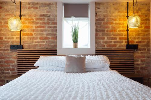 a bedroom with a large white bed with a window at The Dolphin Hotel & Restaurant in Pembroke Dock