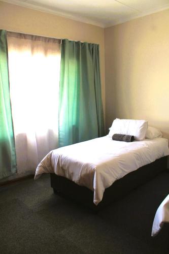 Ένα ή περισσότερα κρεβάτια σε δωμάτιο στο Courtyard Guest House