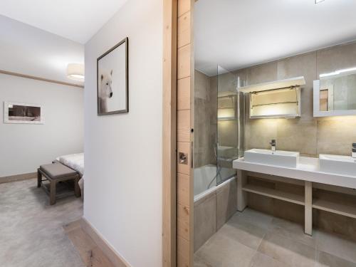 ein Bad mit einem Waschbecken, einer Badewanne und einem Bett in der Unterkunft Appartement 3P au coeur de Courchevel, proche commerces et pistes, parking inclus - FR-1-562-10 in Courchevel