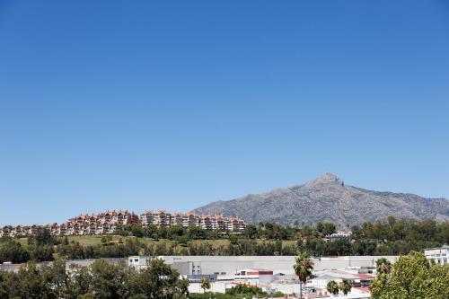 a view of a city with a mountain in the background at Ranhomes rentals apartments in Nueva Andalucia