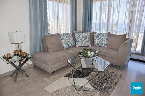 a living room with a couch and a glass table at Torre con roof garden y piscina vista al mar in Mazatlán