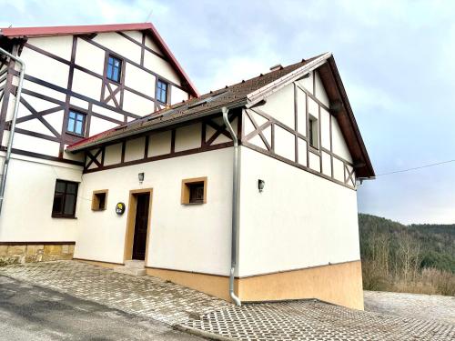 a large white building with a brown roof at Resort Mezná in Hřensko