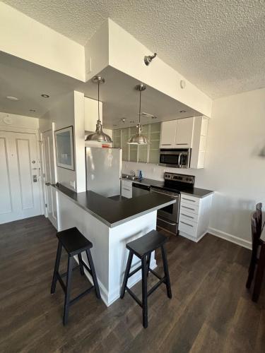 a kitchen with white cabinets and a black counter top at Downtown Studio with Full Kitchen and Bath in Indianapolis