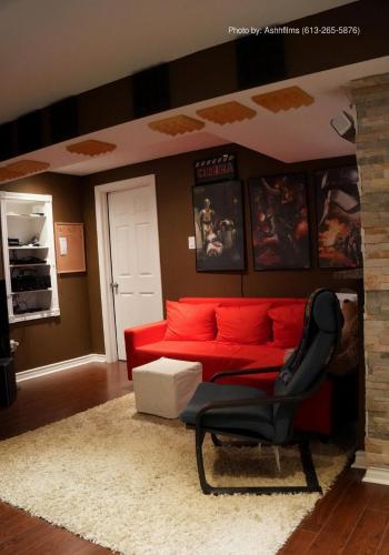 a living room with a red couch and a chair at Fosterbrook Parkside Retreat in Ottawa