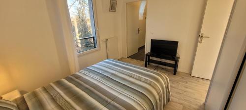 une chambre avec un lit et une télévision à écran plat dans l'établissement Cap soleil, à Dammarie-les-Lys