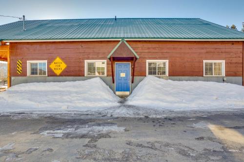 a red building with a blue door and snow at Private Hot Tub and Mtn Views Garden Valley Apt! in Crouch