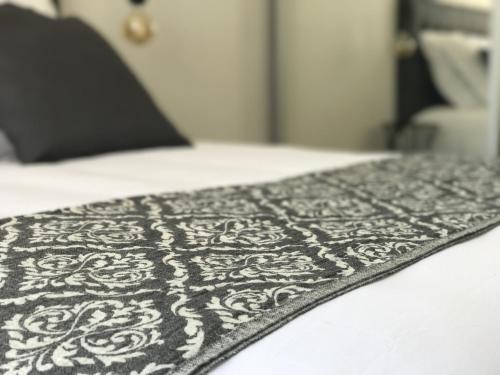 - une couverture noire et blanche sur un lit dans l'établissement Sweet Holiday, à Porto-Vecchio