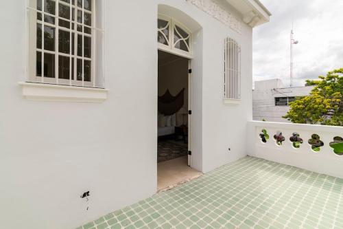 a white house with a green tiled courtyard at Casa Damiana in Mérida