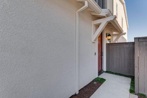 a white house with a red door and a fence at 7 Mi to Folsom Lake Sacramento Area Apartment in Folsom