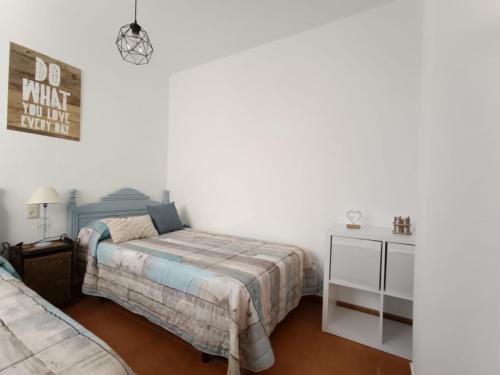 a bedroom with two beds and a white wall at Apto Mediterraneo WIFI GRATIS in San José