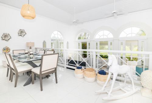 a white dining room with a table and chairs at Royal Westmoreland - Cassia Heights 8 by Island Villas in Saint James