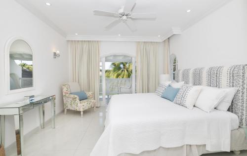 a white bedroom with a bed and a desk at Royal Westmoreland - Cassia Heights 8 by Island Villas in Saint James