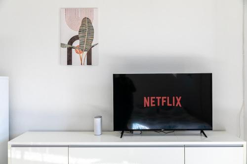 a flat screen tv sitting on top of a white cabinet at San Marco Apt - Loft a 5 minuti dall'aeroporto con parcheggio privato interno in Quinto di Treviso