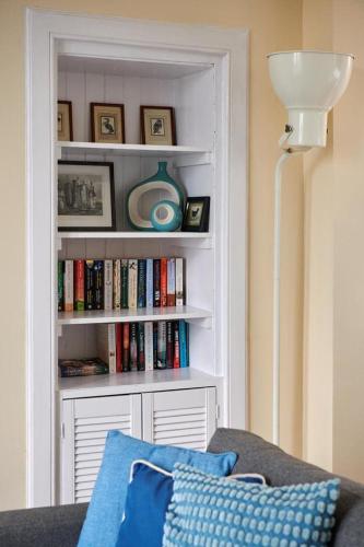 a living room with a book shelf filled with books at Swan Cove Apartment Gourock in Gourock
