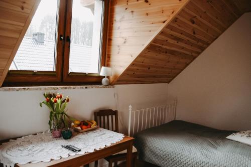 a room with a table and a bed and a window at Apartamenty Wieżyca 17 in Wieżyca