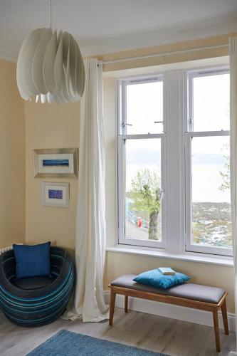 a living room with a bench and a window at Swan Cove Apartment Gourock in Gourock
