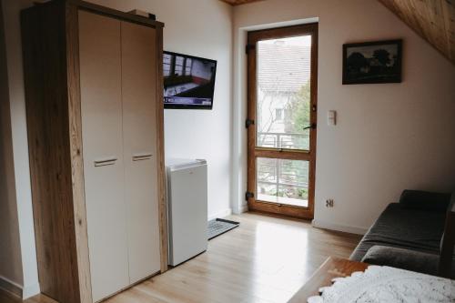 a living room with a door open to a living room at Apartamenty Wieżyca 17 in Wieżyca