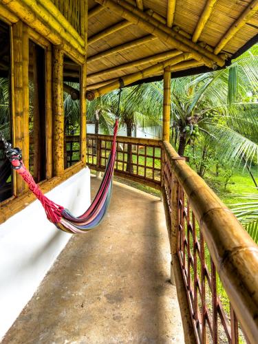 a hammock hanging from a porch of a house at Eco-Lodge Deseo Bamboo in Santa Catalina