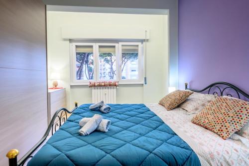 a blue bed in a bedroom with a window at "A casa dei Nonni" House near the metro C in Rome