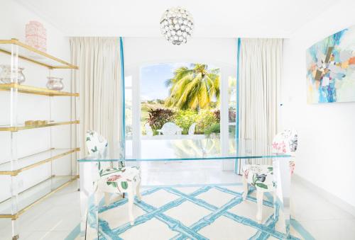 a glass table and two chairs in a room with a window at Royal Westmoreland - Cassia Heights 8 by Island Villas in Saint James