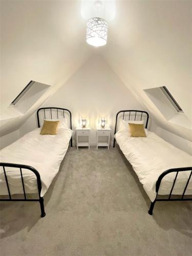 a attic room with two beds and two night stands at 8 Ashton Villa in Broadstairs