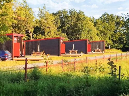 a group of buildings with benches in a field at 4 star holiday home in KARLSKRONA in Karlskrona